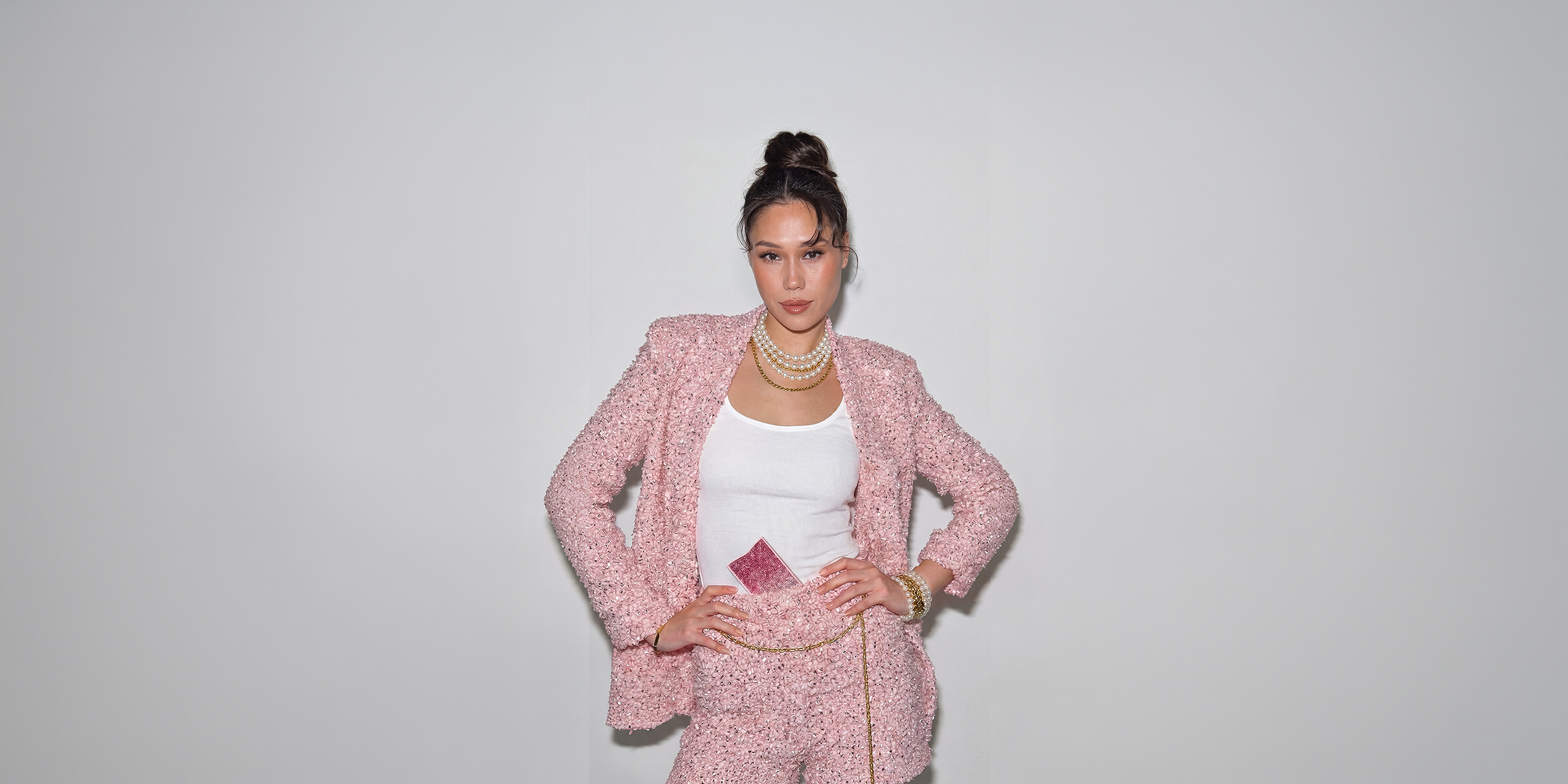 Woman in a pink editorial outfit wearing the NETIC Crystal Wallet as part of a slim wallet for women styling concept