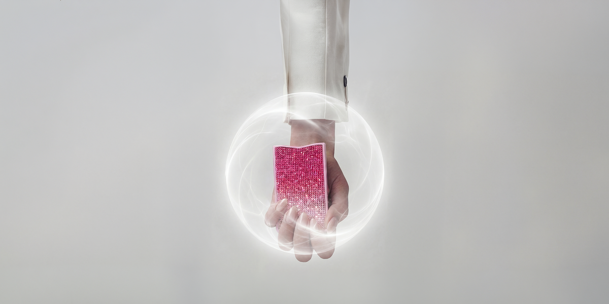 Hand holding the pink NETIC Slim Jewellery Wallet with an editorial energy shield effect symbolising RFID protection
