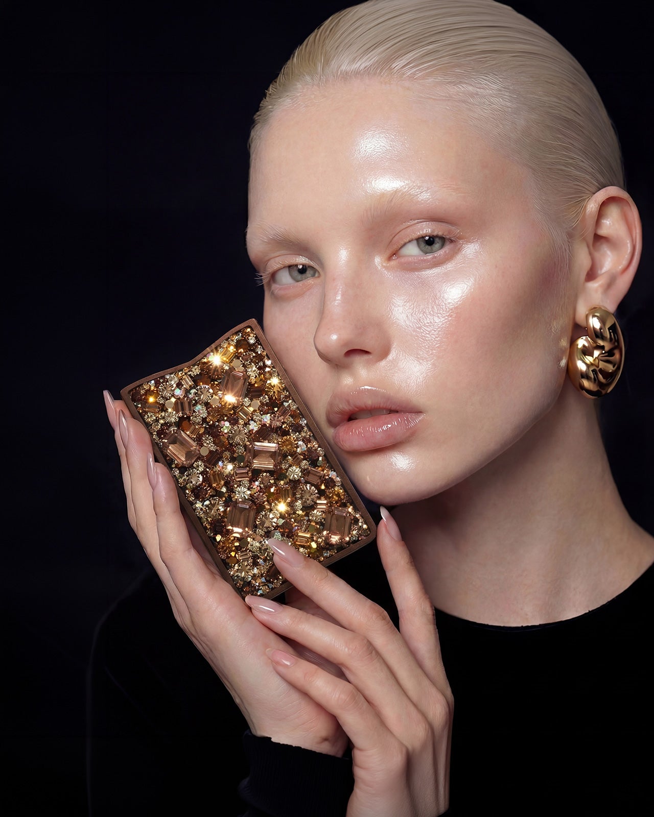 NETIC Couture Wallet held by woman against cheek, gold topaz crystals, limited edition luxury compact cardholder