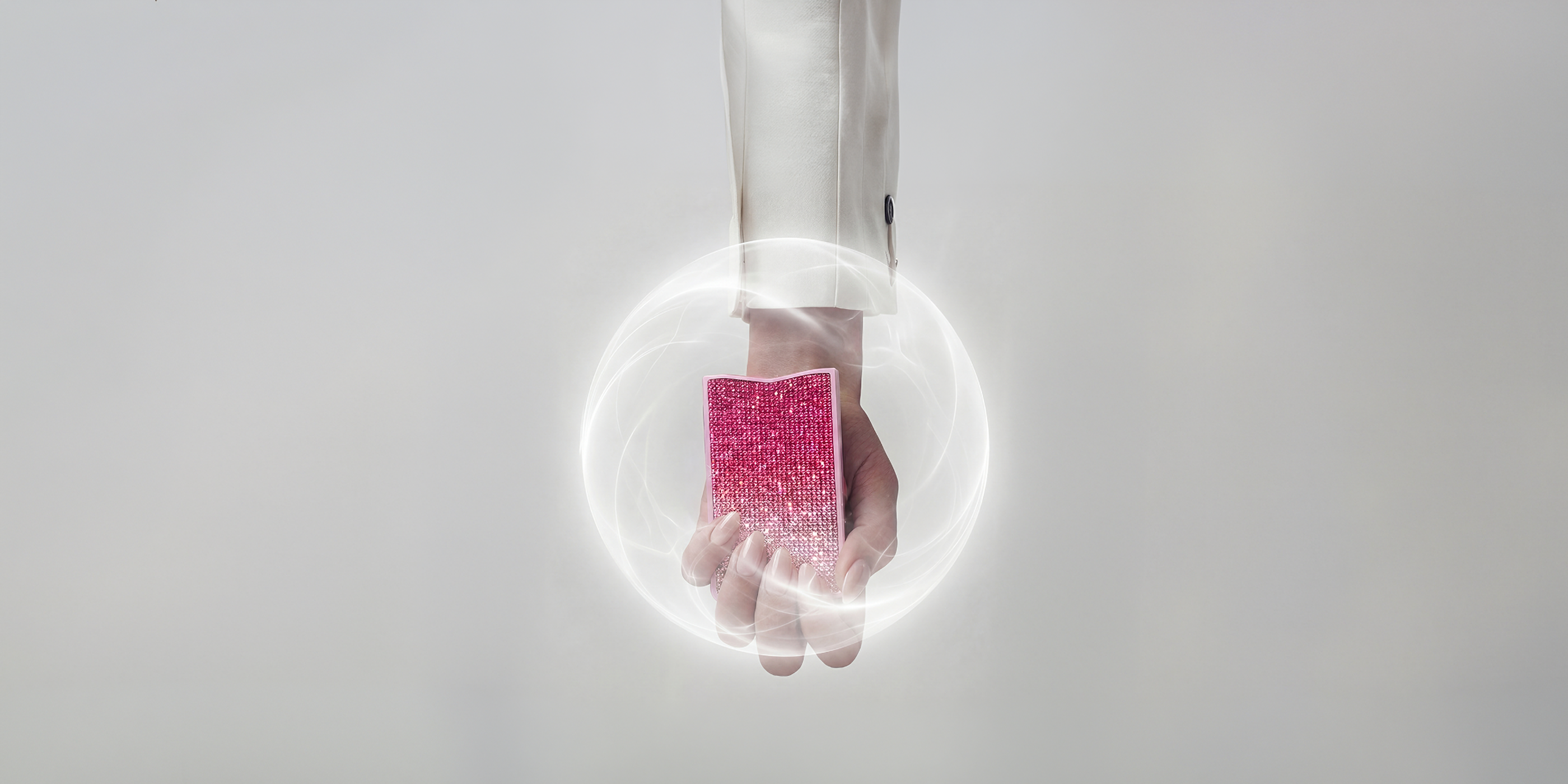 Hand holding the pink NETIC slim wallet with an editorial energy shield effect symbolising RFID protection