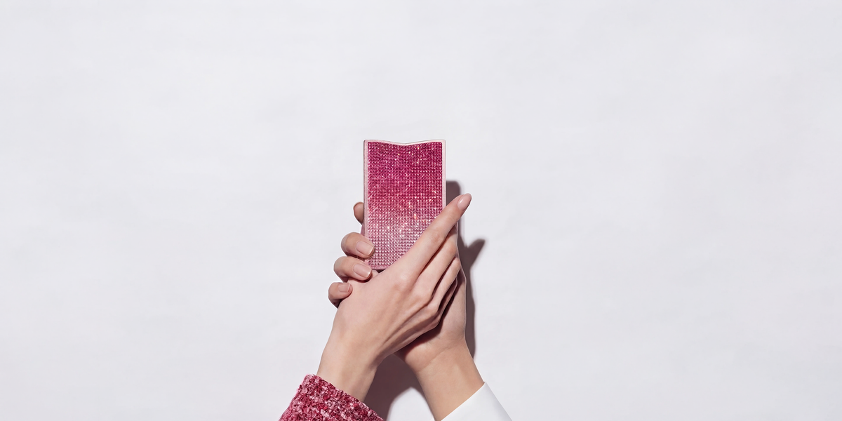 Hands holding the pink NETIC Slim Jewellery Wallet